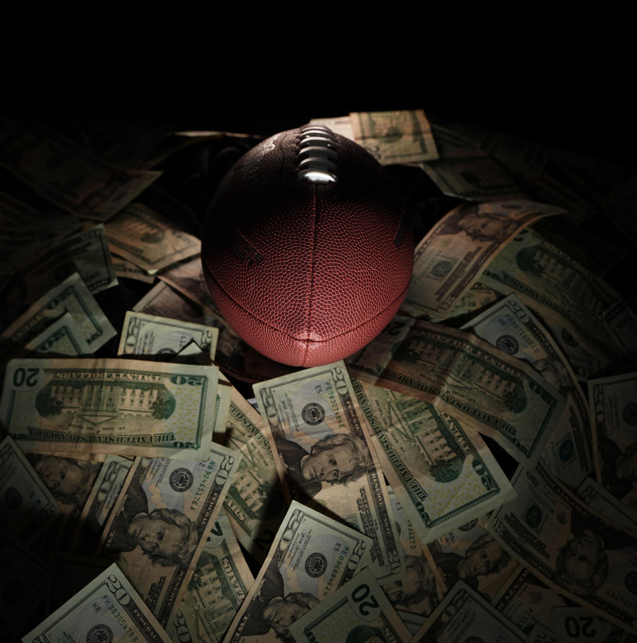 Football resting on a stack of cash, representing the insider edge behind every pick